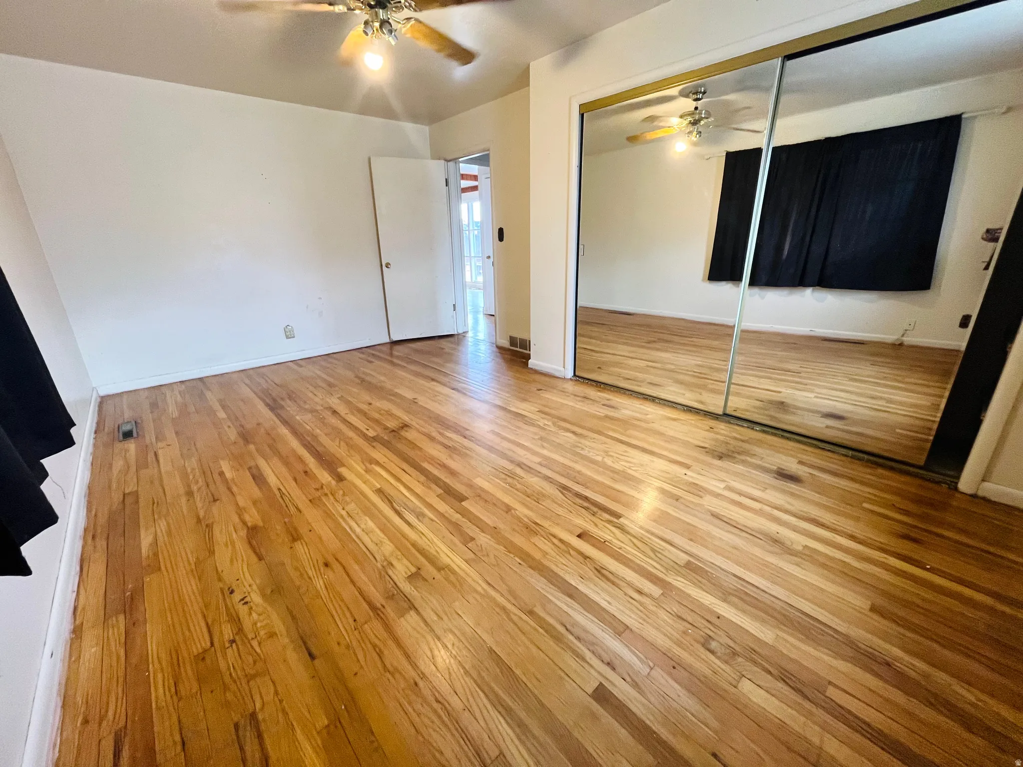 Bedroom featuring hardwood floors and mirrored closet doors.