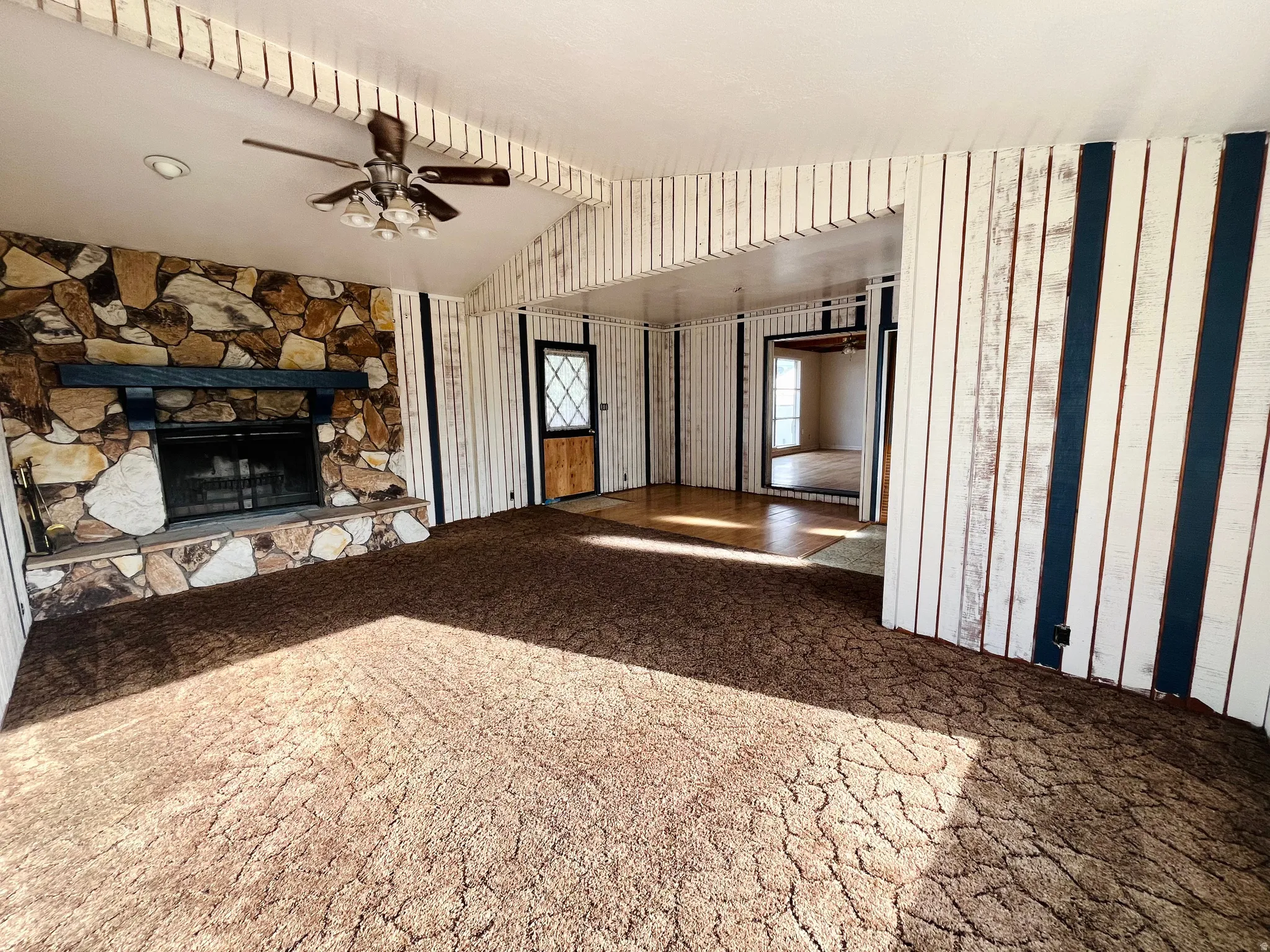 Generous living area with carpet and a cozy wood-burning stove