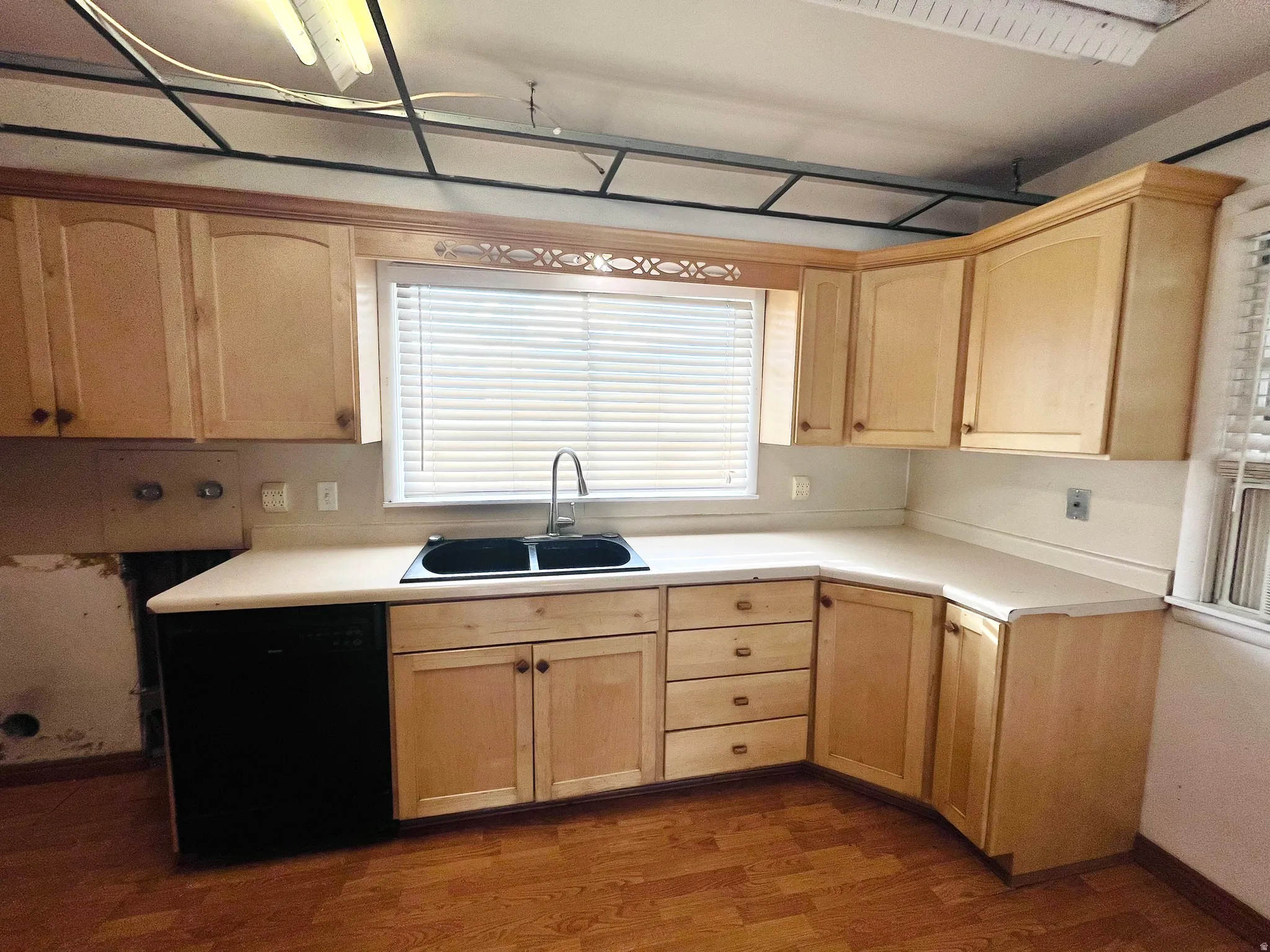 Kitchen with wood-finish cabinetry, light-toned countertops, and wood-finish flooring