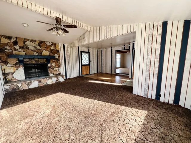 Generous living area with carpet and a cozy wood-burning stove