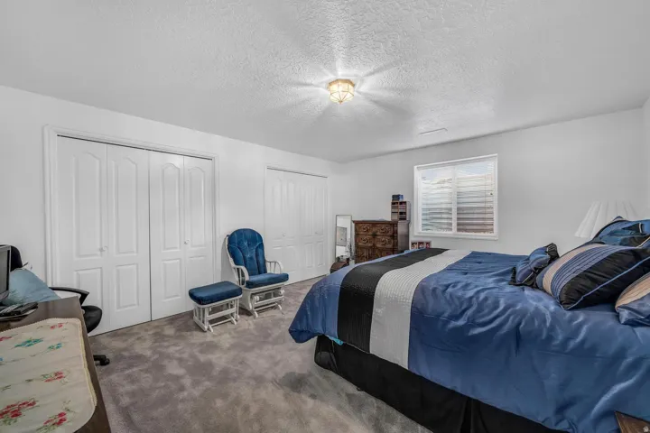 White walls, gray carpet, and multiple bi-fold closet doors