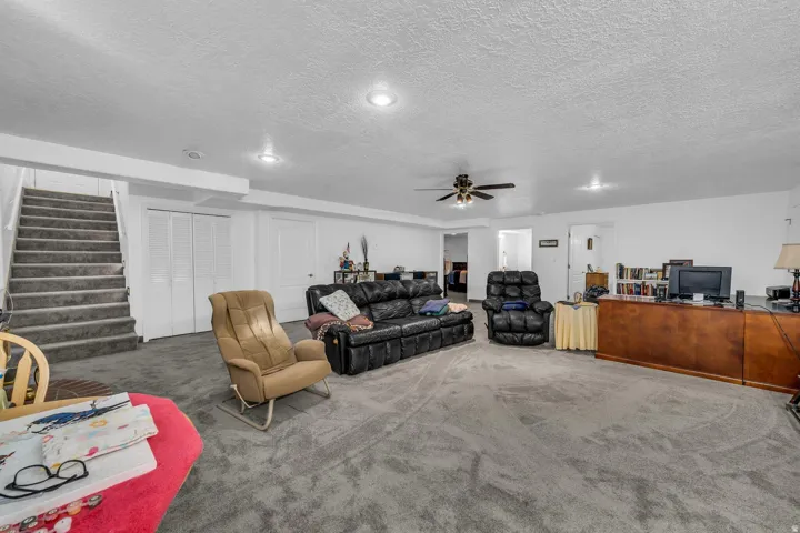 Carpeted flooring, recessed lighting, ceiling fan, white walls, built-in shelving
