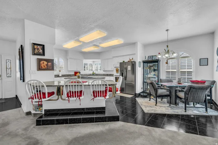 Kitchen with white cabinetry, stainless steel appliances, and a breakfast bar