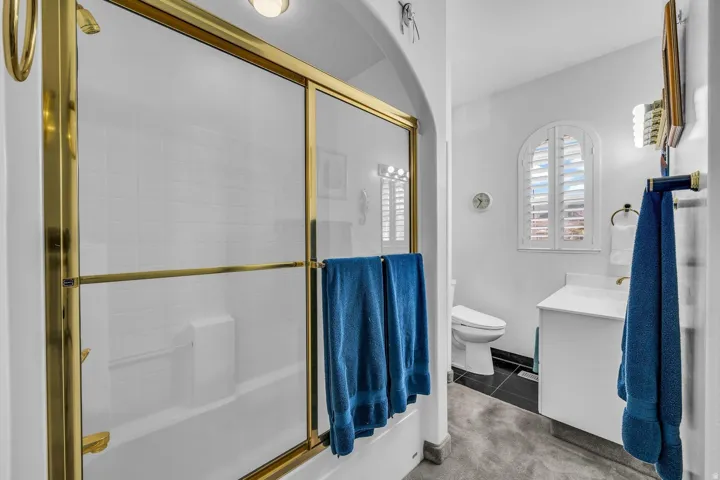 Tub/shower combination with gold-finish sliding glass enclosure