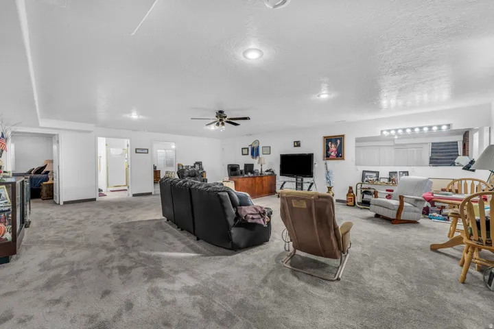 Spacious room featuring neutral carpet flooring, recessed lighting, a ceiling fan, and white walls