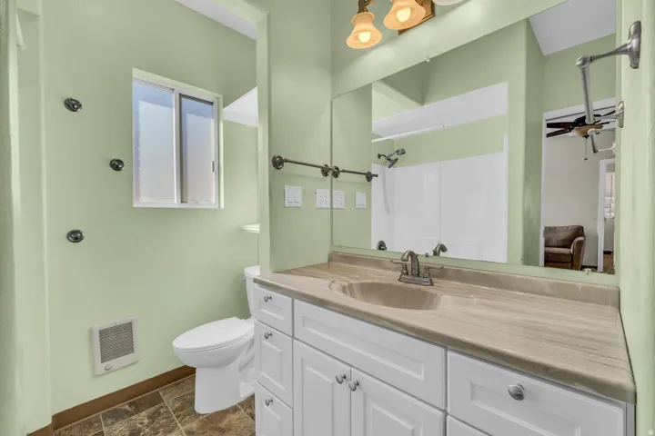White vanity with brushed nickel hardware, integrated sink, and a coordinating countertop