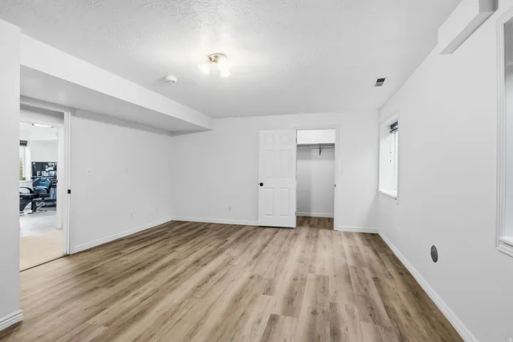 Spacious interior featuring wood-finish flooring, white walls, and an overhead light fixture
