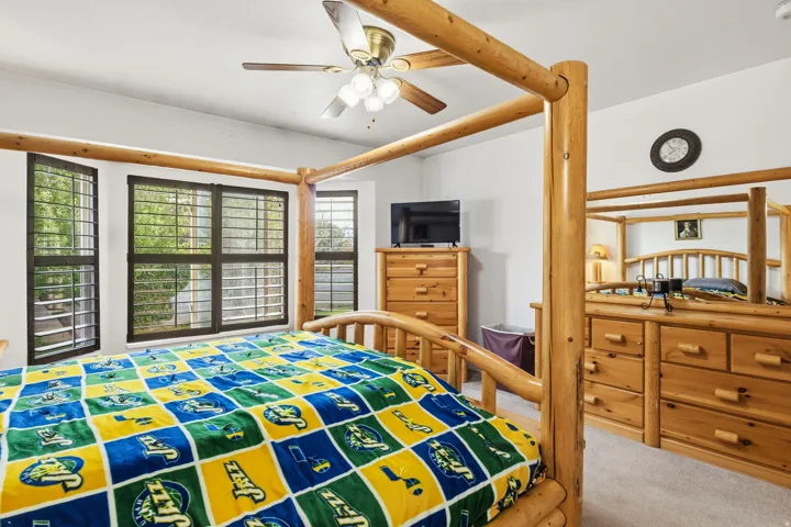 Recessed lighting, ceiling fan, multiple windows with plantation shutters, light neutral wall color, and carpet flooring