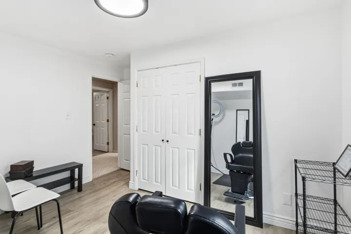 Light wood-finish flooring, white walls, flush-mount ceiling light, and bi-fold closet doors