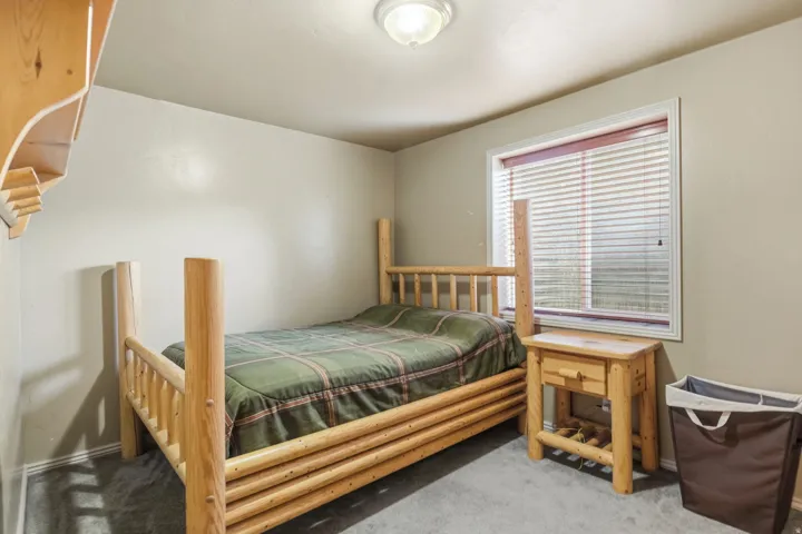 Carpeted flooring with a window featuring blinds