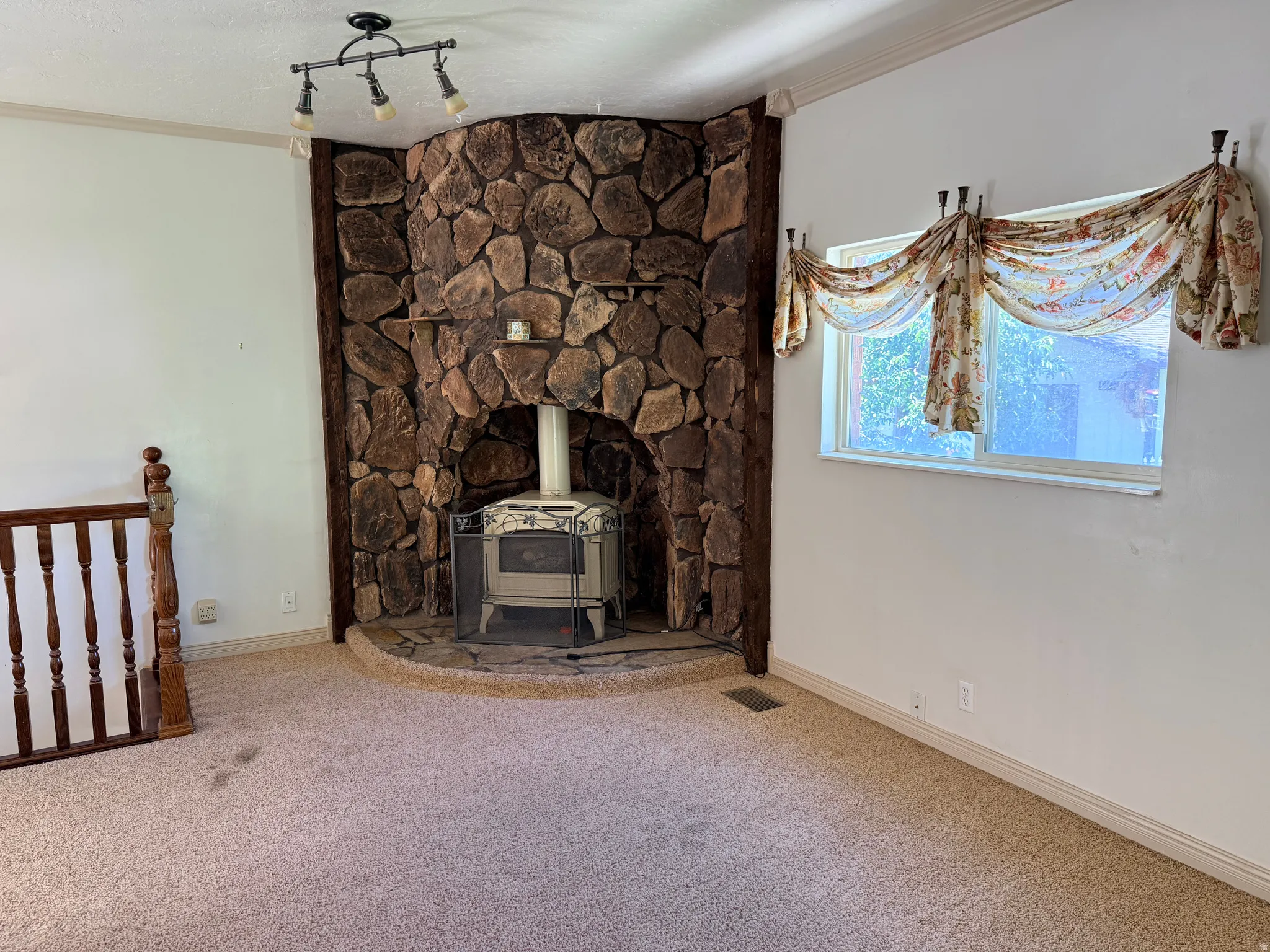 Stone-clad fireplace with a wood-burning stove and a raised hearth