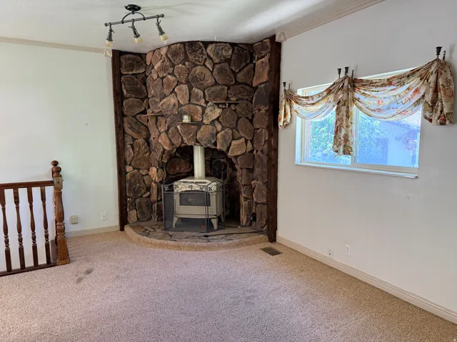 Stone-clad fireplace with a wood-burning stove and a raised hearth