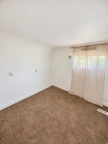 Carpeted flooring, white walls, flush-mounted wall sconce, rectangular window, white trim