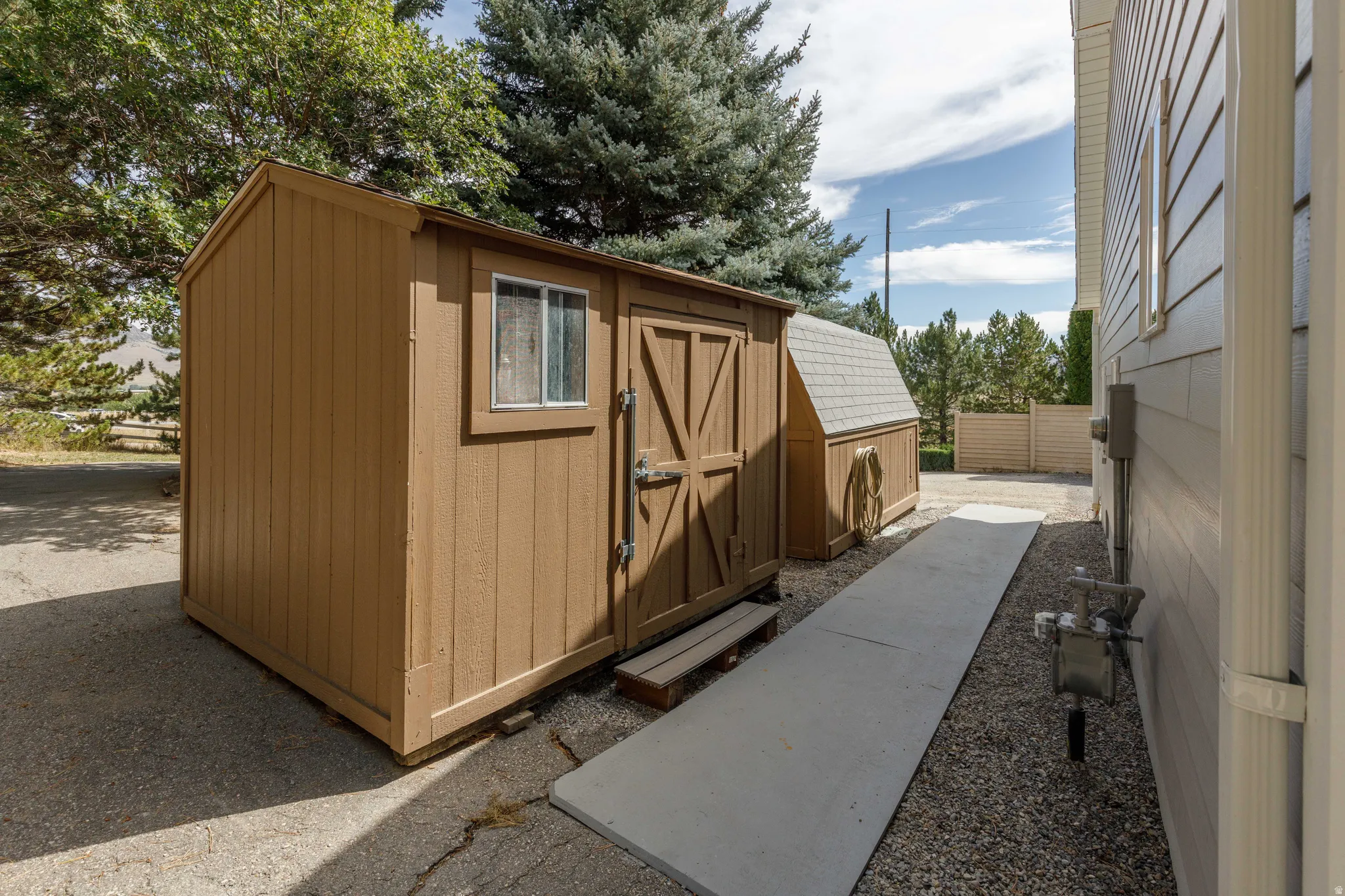 Freestanding shed with a window, dual doors, and a secondary smaller shed