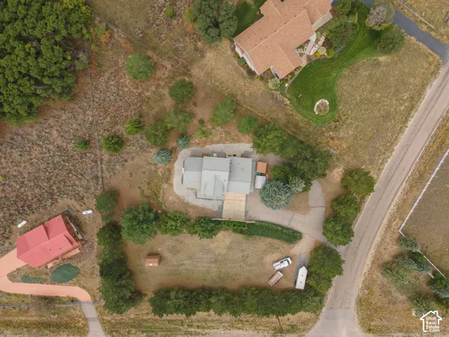 Expansive property featuring multiple structures, mature trees, and natural landscaping