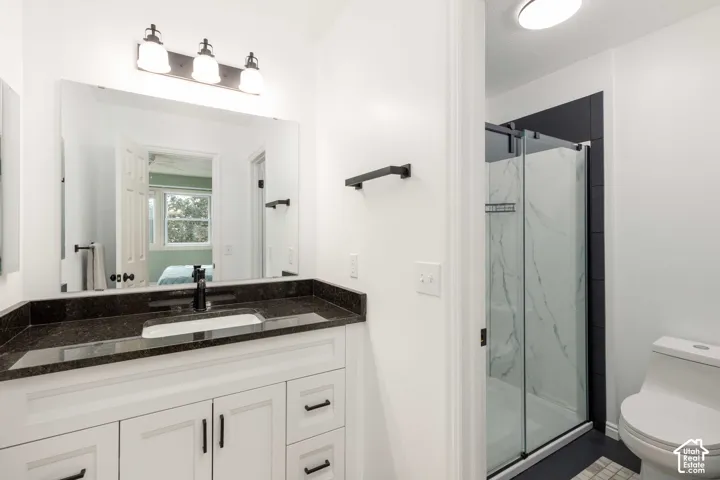 Vanity with a dark stone countertop, undermount sink, and matte black fixtures