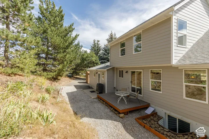 Rear exterior with light gray siding, multi-level design, and a lower-level window well