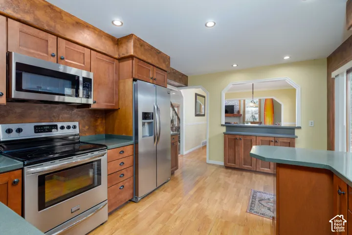 Kitchen featuring stainless steel appliances, wood-finish cabinetry, recessed lighting, and wood-finish flooring