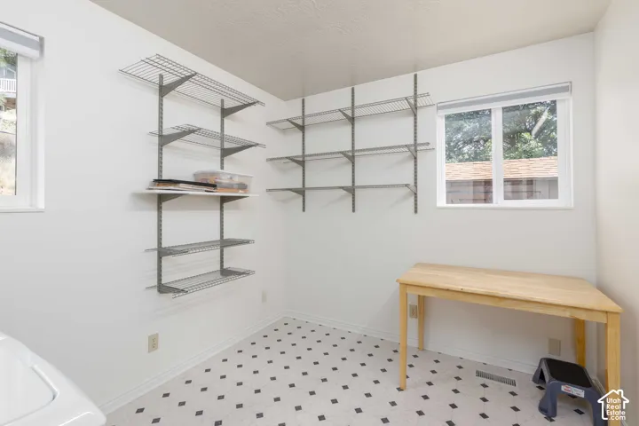 White walls, patterned flooring, and two windows