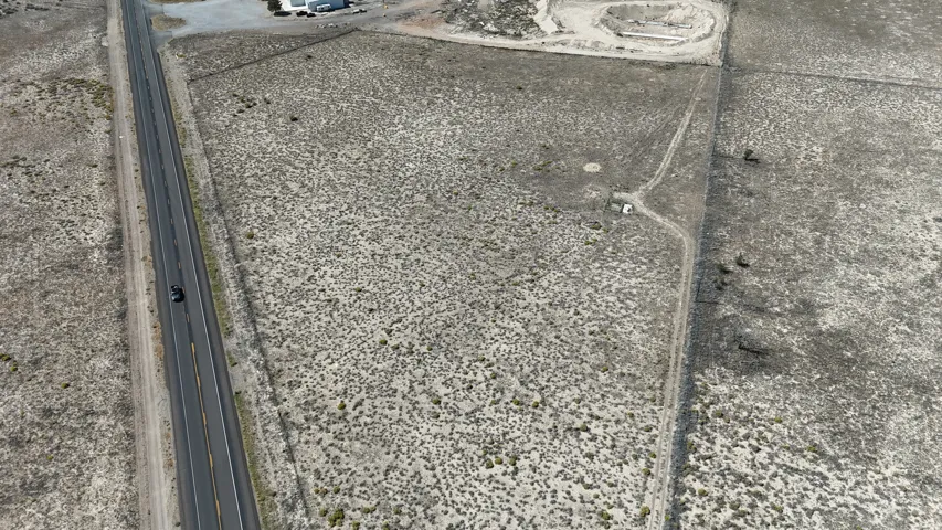 Expansive land parcel featuring open terrain and a paved roadway
