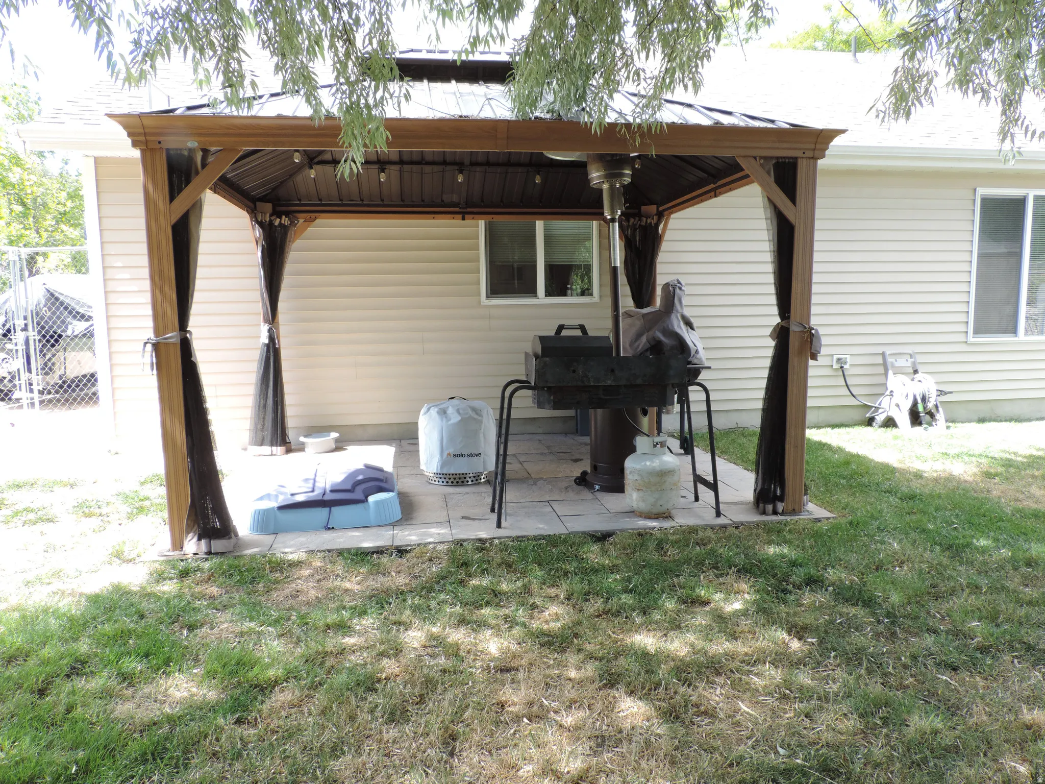 Freestanding patio gazebo with wood-look posts and a metal roof