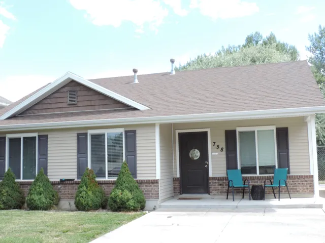 Siding and brick facade with a brown shingle roof