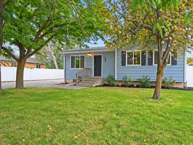 Exterior featuring light blue siding, black window shutters, a front entry with concrete steps