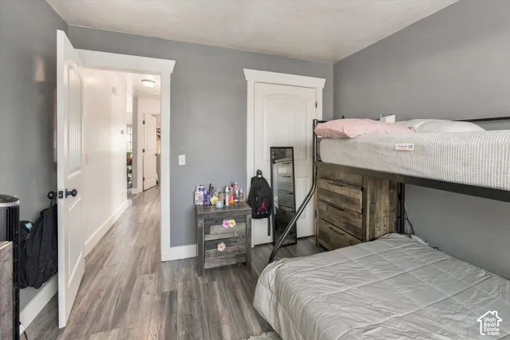 Wood-finish flooring, white trim, and a paneled interior door