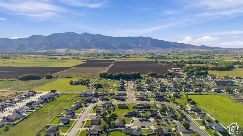 Expansive mountain range backdrop and surrounding green fields