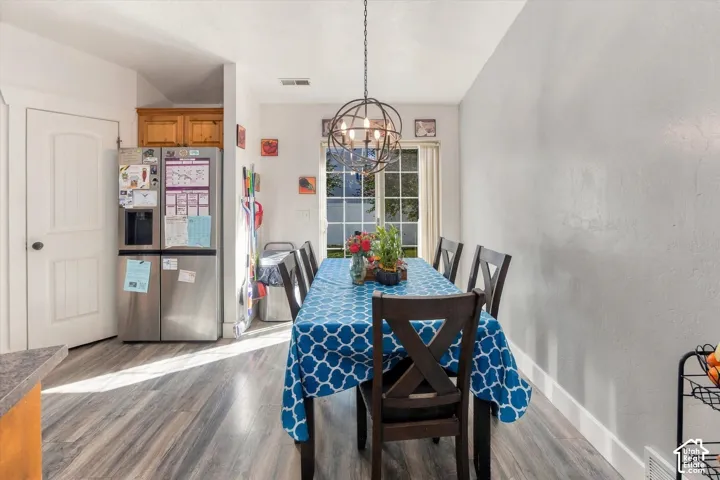 Wood-finish flooring, overhead spherical light fixture, white interior walls, rear exterior window, and white trim molding