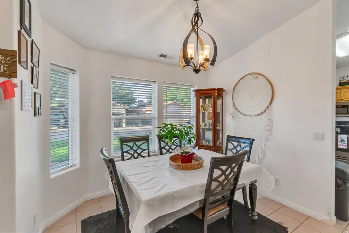Bay window with multiple windows, vaulted ceiling, tile flooring, and an open concept layout with a kitchen pass-through