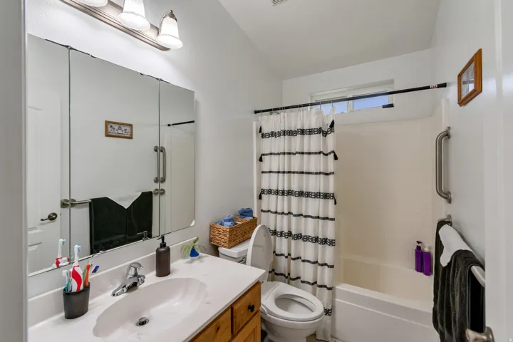 Bathroom featuring a vanity with a drop-in sink, a built-in medicine cabinet, and a bathtub with an integrated shower