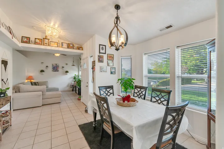 Open-concept living space with tile flooring, vaulted ceiling, and recessed lighting