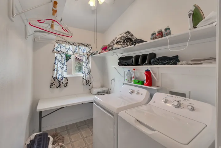 Laundry area featuring a window, built-in shelving, a folding counter, and a ceiling fan