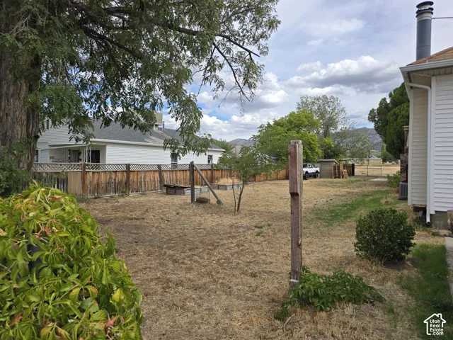 Expansive property grounds featuring a wooden fence perimeter and mature trees