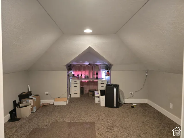 Carpeted room featuring an angled ceiling and built-in alcove
