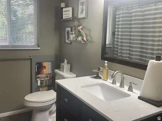 Vanity with integrated sink, stone-finish countertop, and brushed nickel hardware