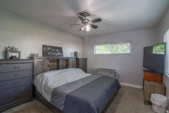 Ceiling fan with integrated lighting, horizontal window with blinds, and neutral wall tones