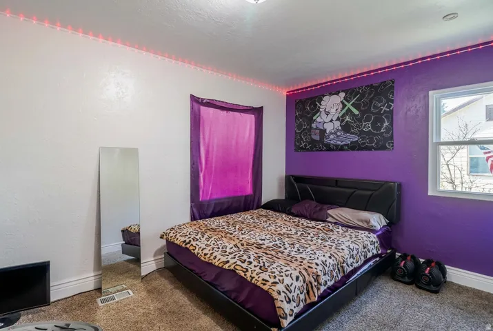 Carpeted flooring, window with natural light, and a white trim baseboard
