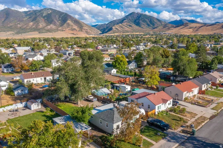 Mountain backdrop, residential neighborhood setting, mature trees, established properties, paved street
