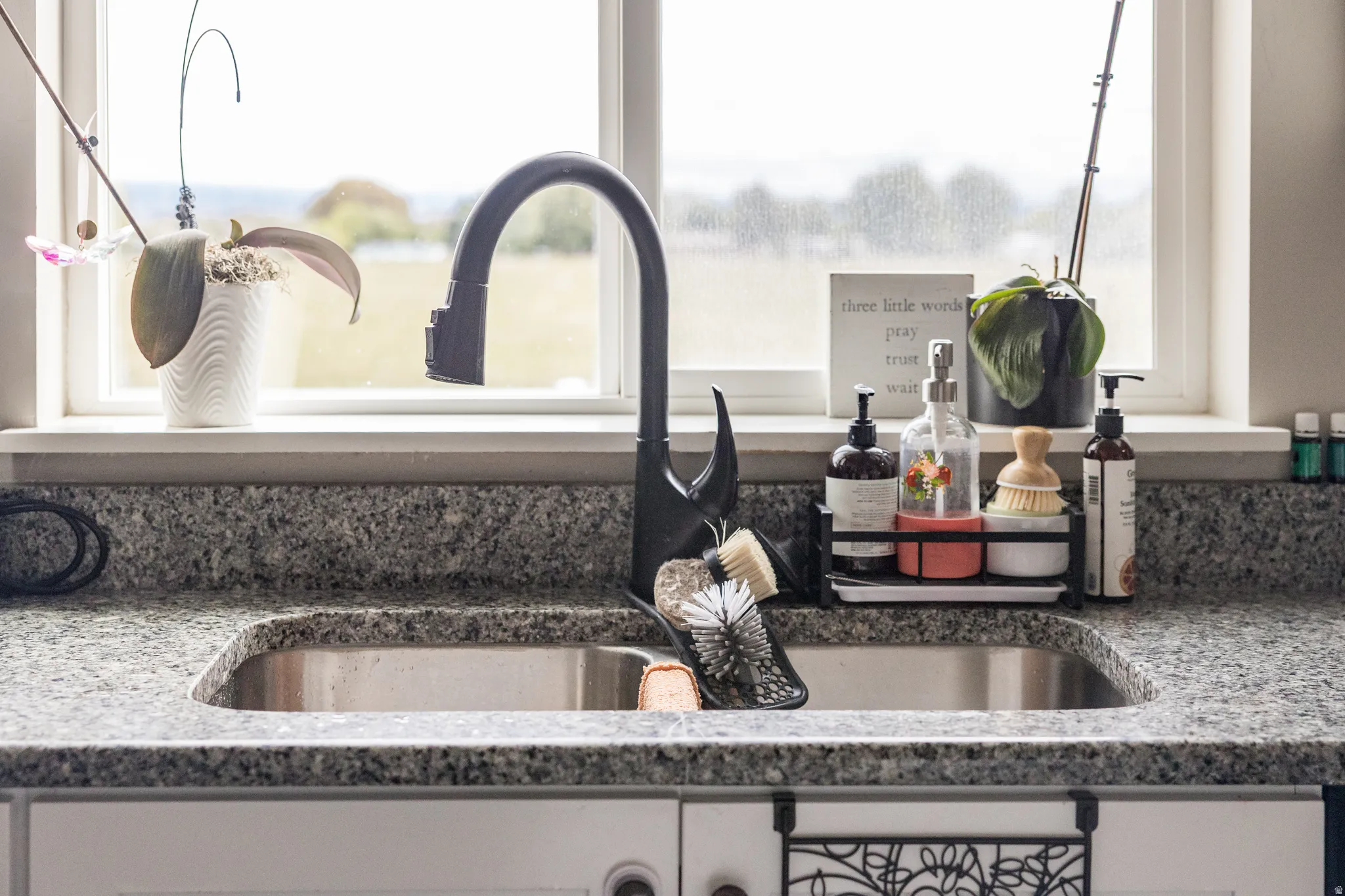 Stainless steel double-basin sink with a matte black gooseneck faucet