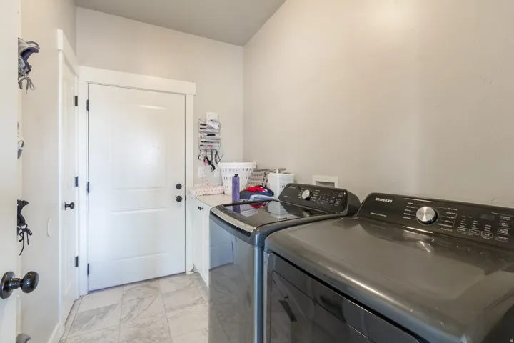 Tile flooring, white cabinetry, light-toned walls, and a solid white door