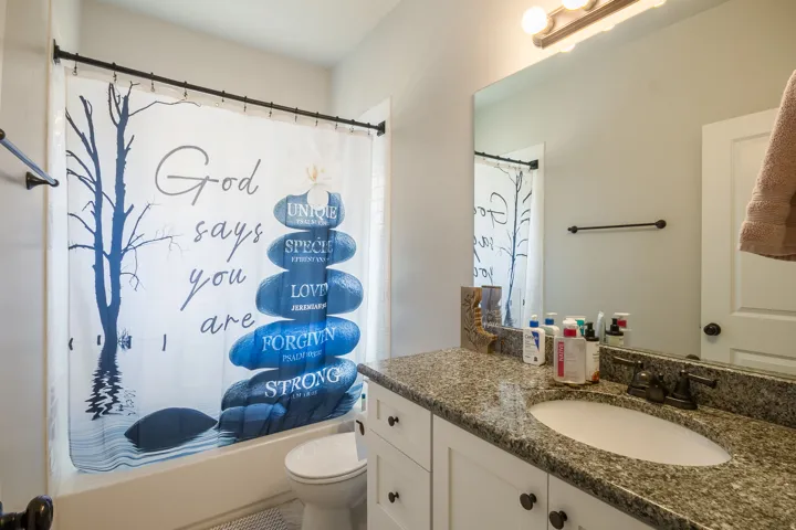 Vanity with granite countertop, integrated sink, and dark bronze-finish faucet