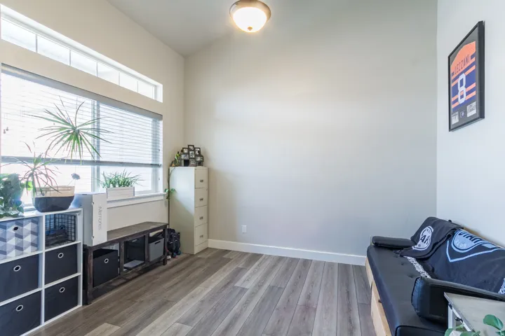Formal Living Room or Office Wood-finish flooring, high ceilings, large window with blinds, and transom window
