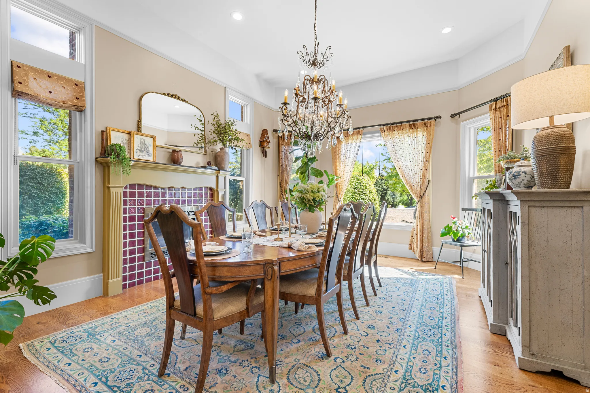 Hardwood flooring, decorative chandelier, recessed lighting, fireplace with tile surround, built-in display shelving