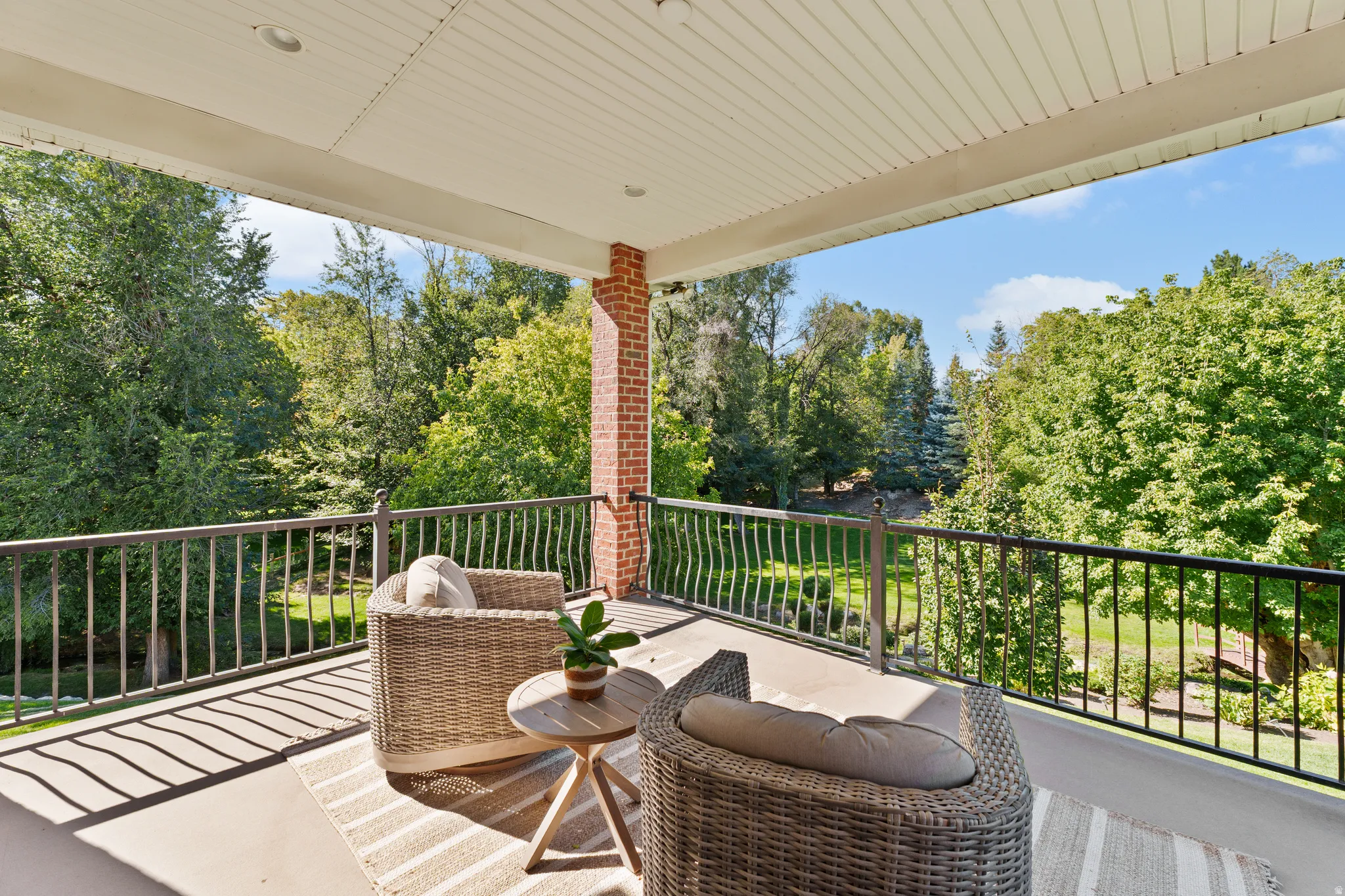 Covered balcony featuring a concrete floor, recessed lighting, and a brick pillar