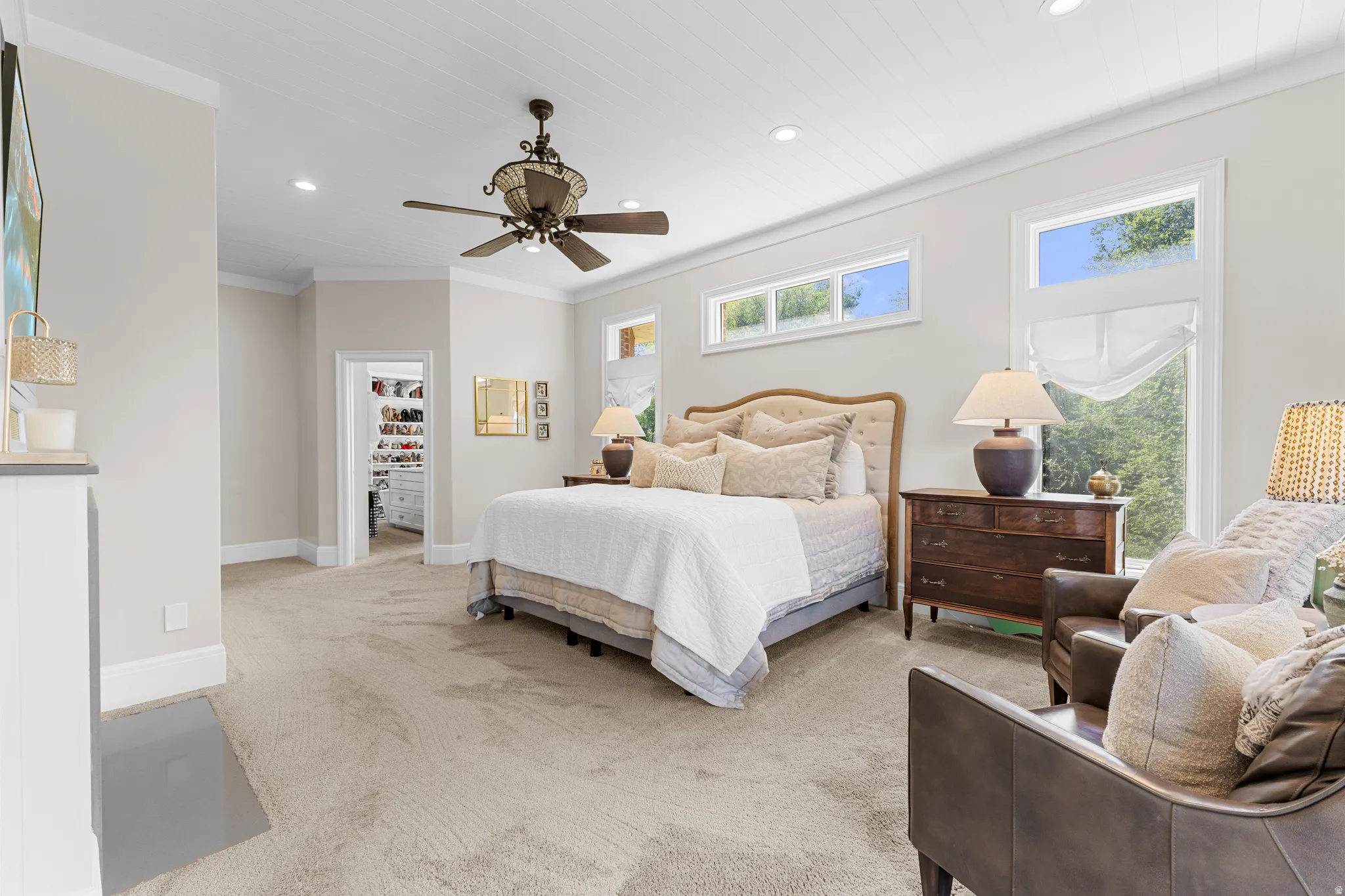 Expansive carpeting with crown molding, recessed lighting, and a ceiling fan