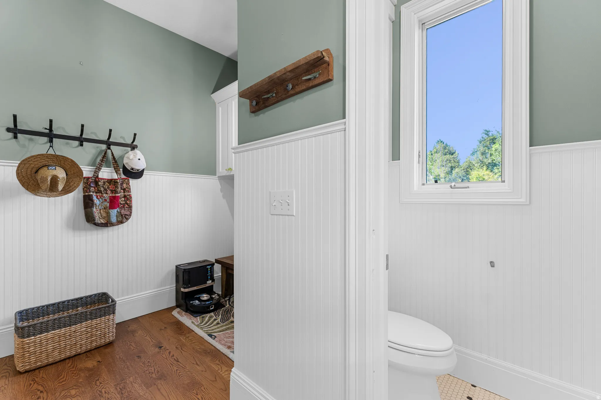 Hardwood-style flooring, wainscoting, built-in cabinetry, and a window with natural light