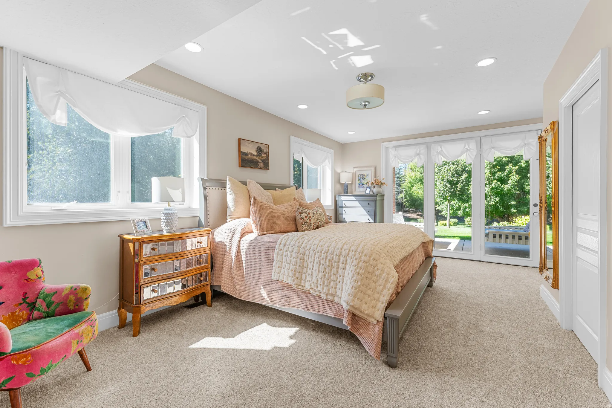 Recessed lighting, light-toned carpeting, and a ceiling-mounted fixture illuminate this space