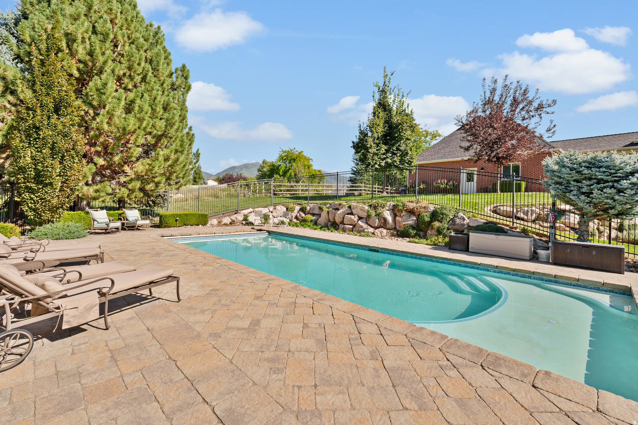 Expansive paver patio surrounding an in-ground swimming pool